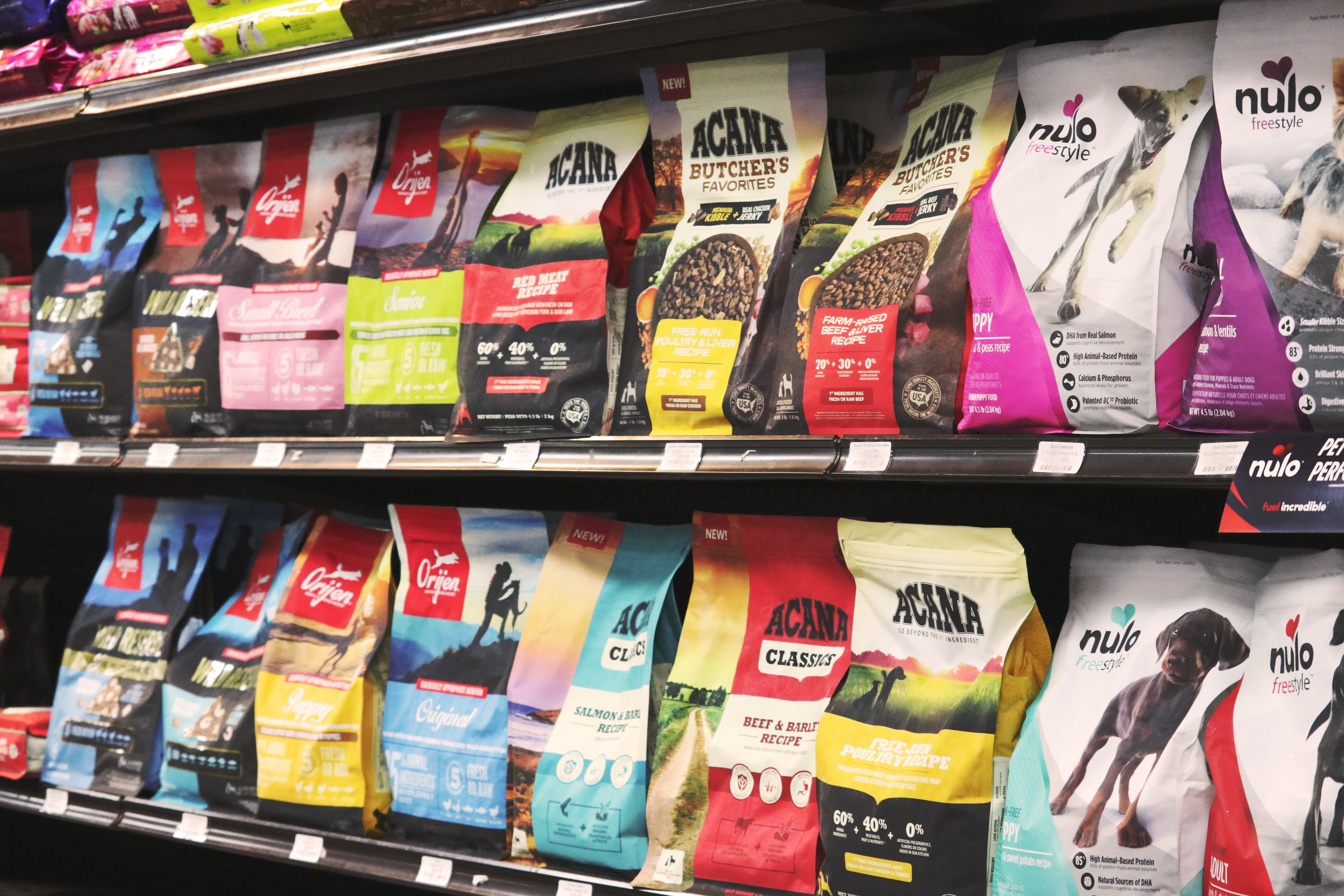 Dry dog food wall featuring Orijen, Acana, and Nulo at Wishbone Pet Co.